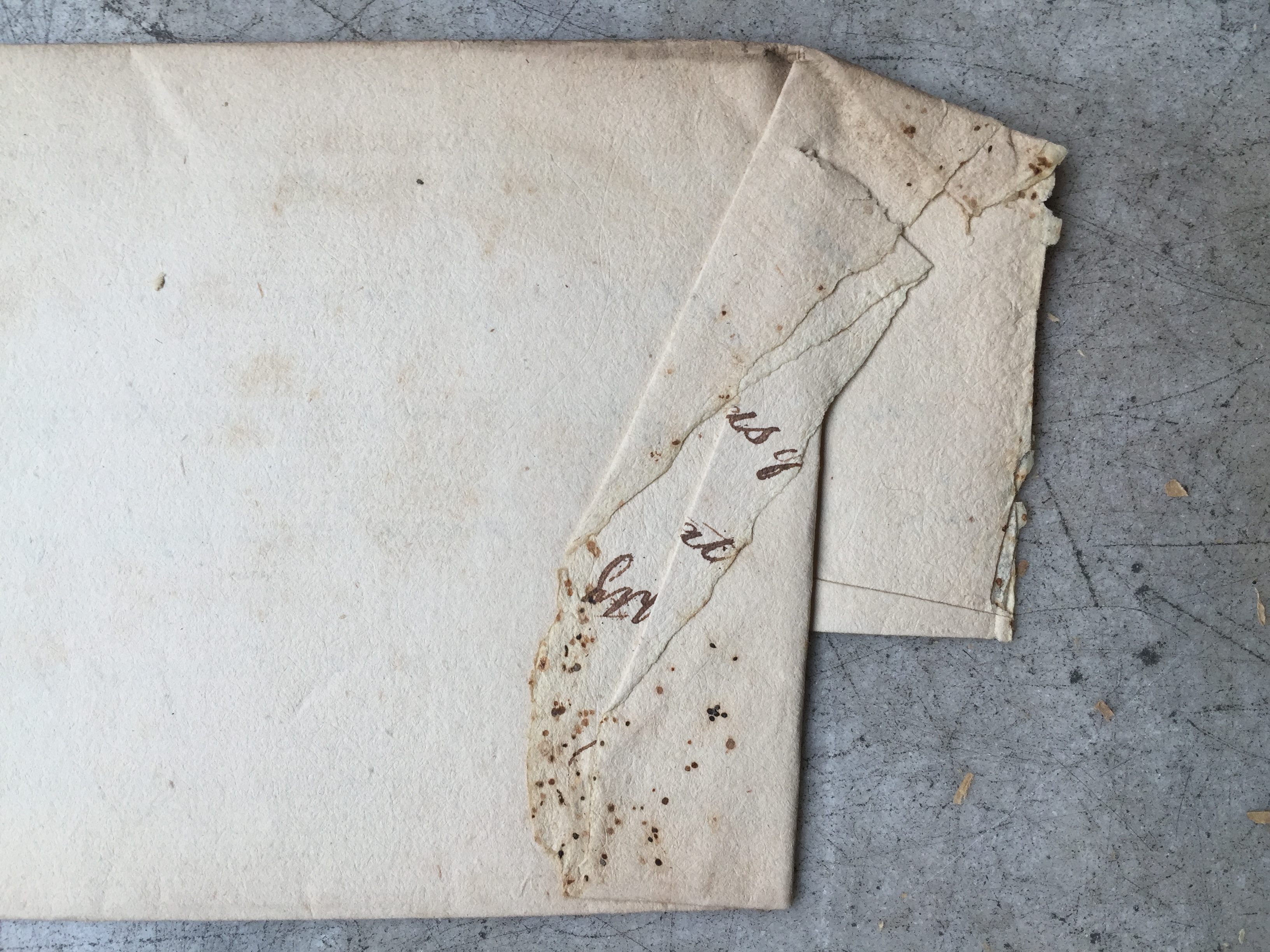 Folded document with small brown and black spots along the right edge.